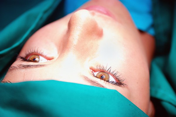 Woman wearing a surgical cap, looking upwards