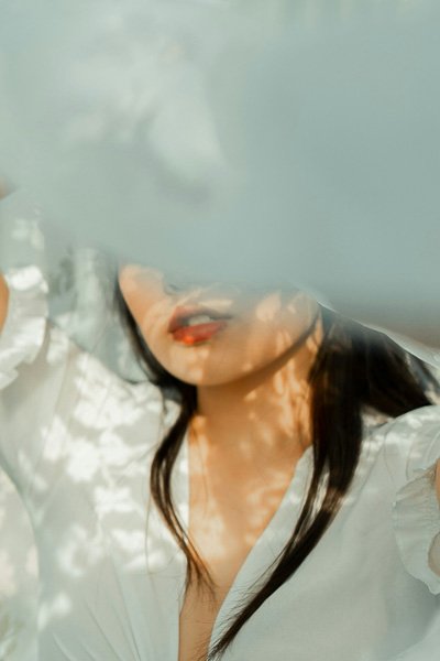 Woman's face behind a translucent veil, lips in focus
