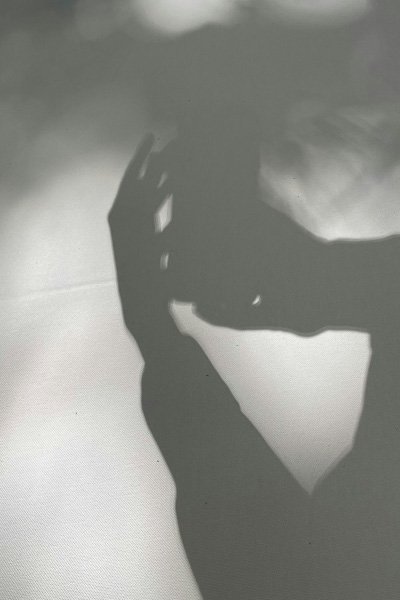 Shadow of a hand cast on a light-coloured surface