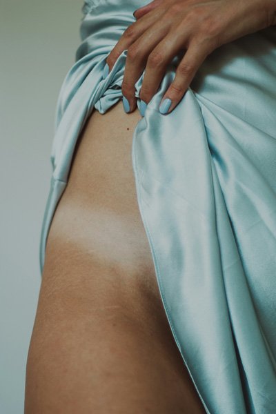 Woman's hip, skirt partially lifted over the thigh