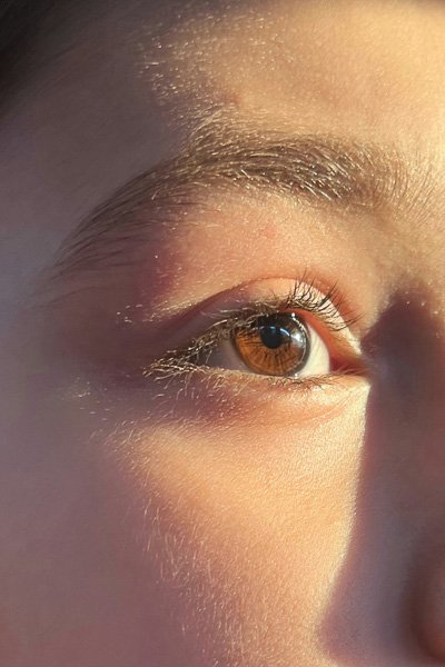 Close-up of an eye and eyebrow in warm light