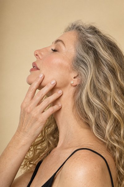 Woman in profile with her eyes closed, hand resting on her chin