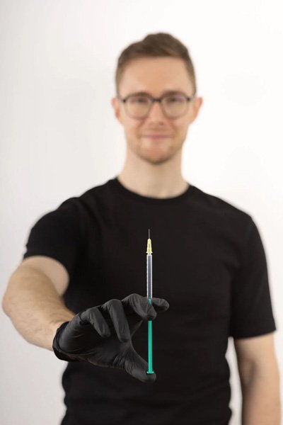 Dr. Matthias Spiegl holding a syringe