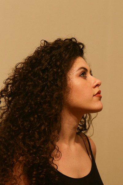 Woman with curly hair in profile, head slightly raised