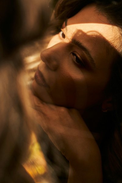Woman's face in warm light with her hand on her chin